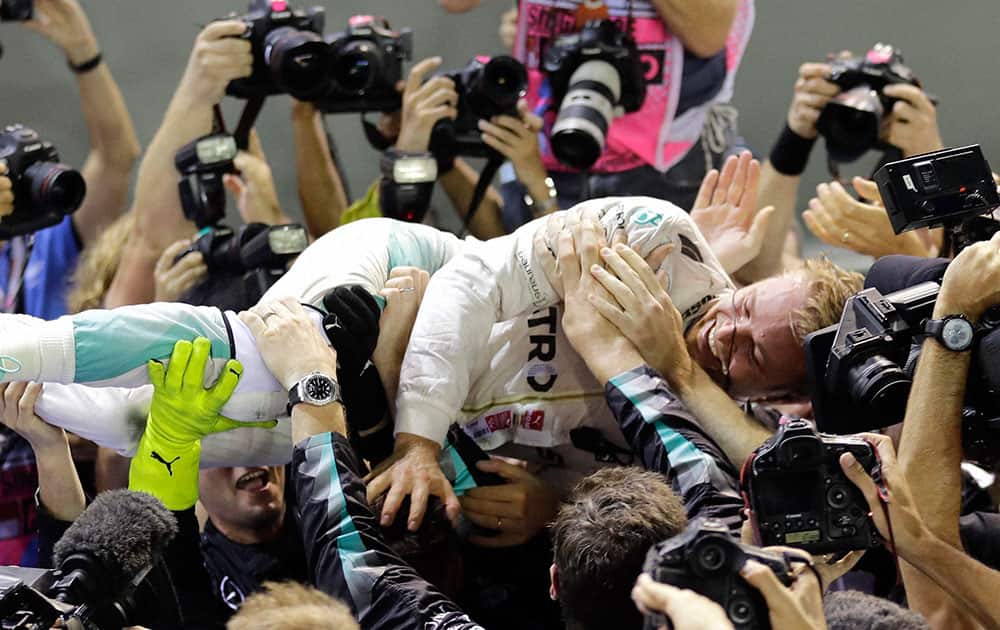 Mercedes driver Nico Rosberg of Germany is embraced by his team after winning the Singapore Formula One Grand Prix