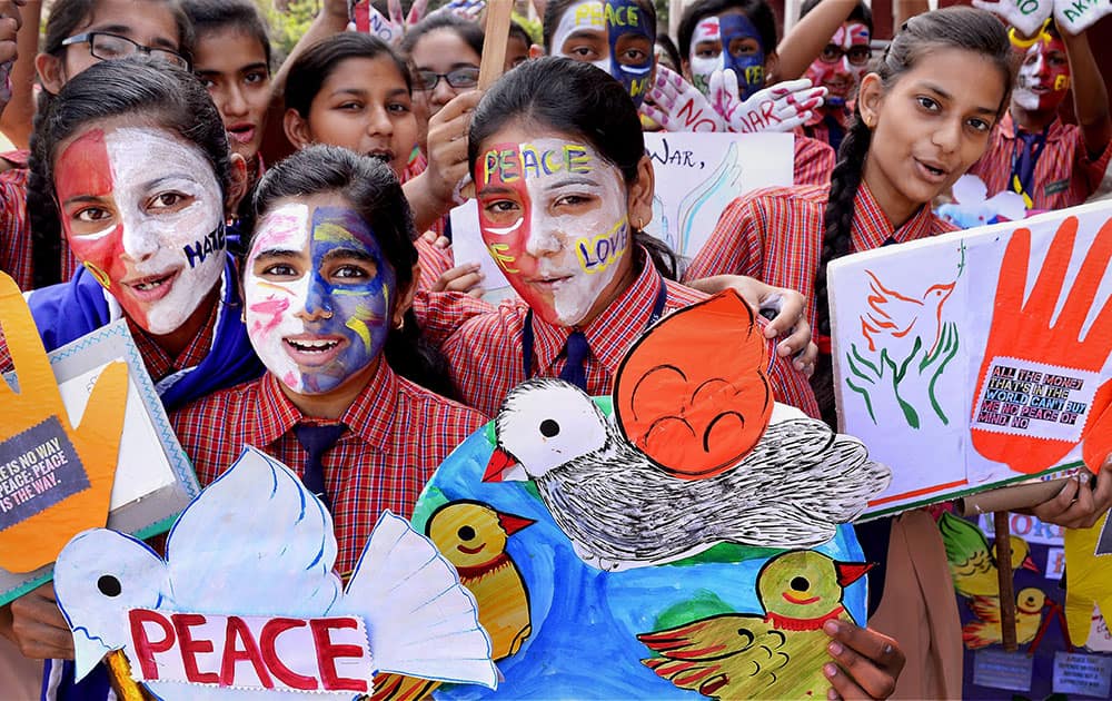 Students paint their faces and hold posters to celebrate the upcoming Peace Day event in Jabalpur