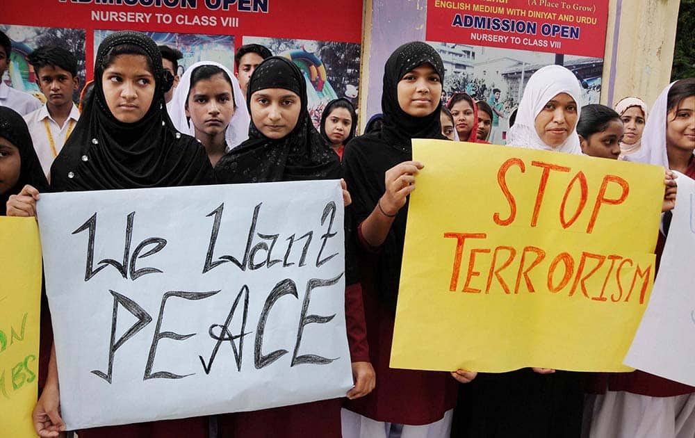School students holds placards during a protest against terror attack