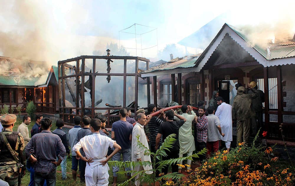 Locals , Army and fire fighters try to douse the major fire at Historical Educational Hanafia High Schoo