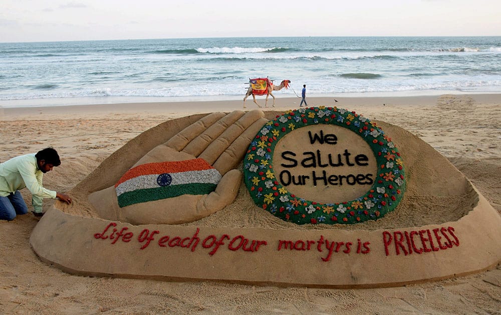 Sand artist Sudarsan Pattnaik creates a sand sculpture on the soldiers who lost their lives in Kashmir with message We salute our Heroes, Life of each of our martyrs is Priceless