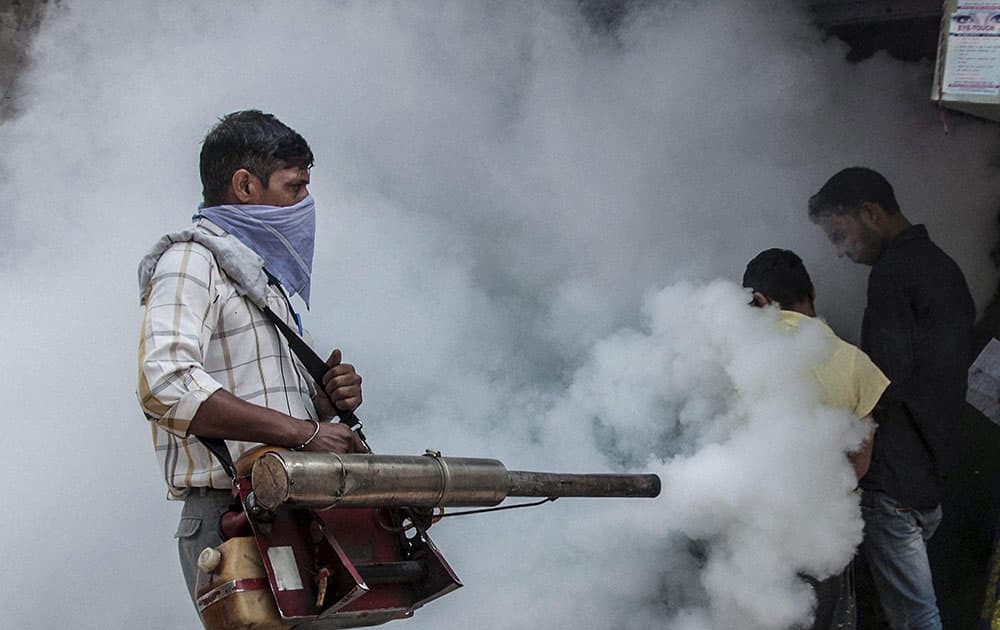 A Municipal Corporation of Delhi (MCD) employee fumigates near Hindu Rao Hospital in New Delhi in the view of mosquito-borne diseases