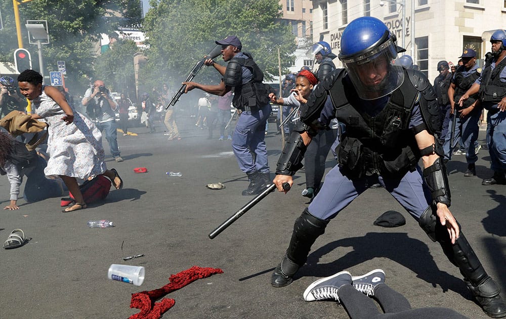 tudents run for cover as police fire stun grenades and rubber bullets in an attempt to disperse them, during their protest for free education