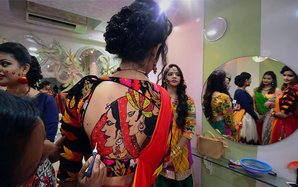 A girl gets a tattoo panited on her back in preparation for forthcoming Navratri festival, in Ahmadabad