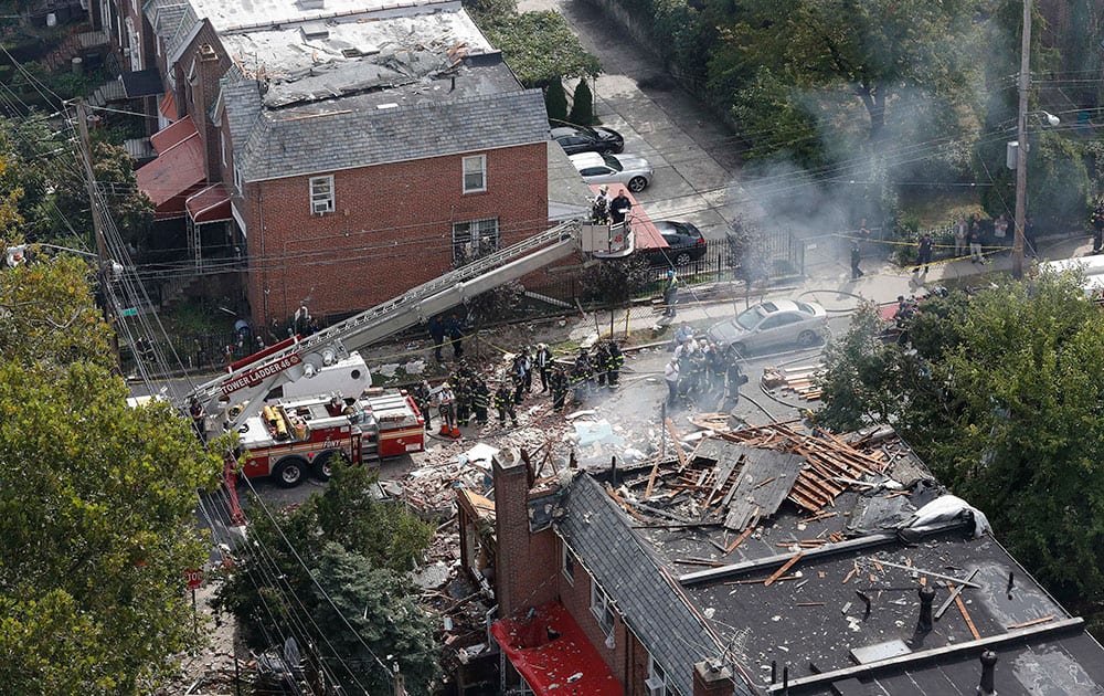 Emergency service personnel work at the scene of a house explosion, in the Bronx borough 