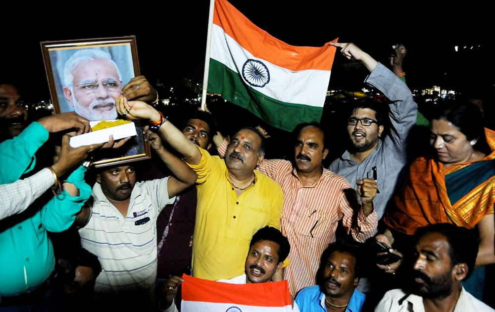 Bharatiya Janta Party ( BJP ) workers offering laddoos to a poster of Prime Minister Narendra Modi to celebrate the surgical strike inside the Pakistan by Indian Army to revenge Uri Attack