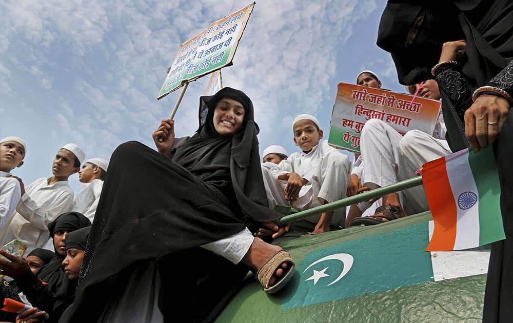 A Muslim girl puts her shoe on Pakistani flag over a tank that was brought after Indo-Pak war in 1971, during a rally in support of Indian army