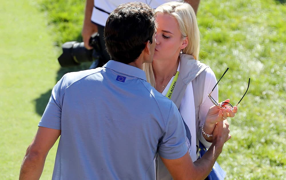 Rafa Cabrera Bello of Europe kisses Sofia Lundstedt on the first tee during singles matches of the 2016 Ryder Cup at Hazeltine National Golf Club