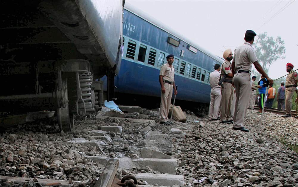 Policemen stand guard in front of the Jhelum Express, whose nine coaches derailed in Ludhiana