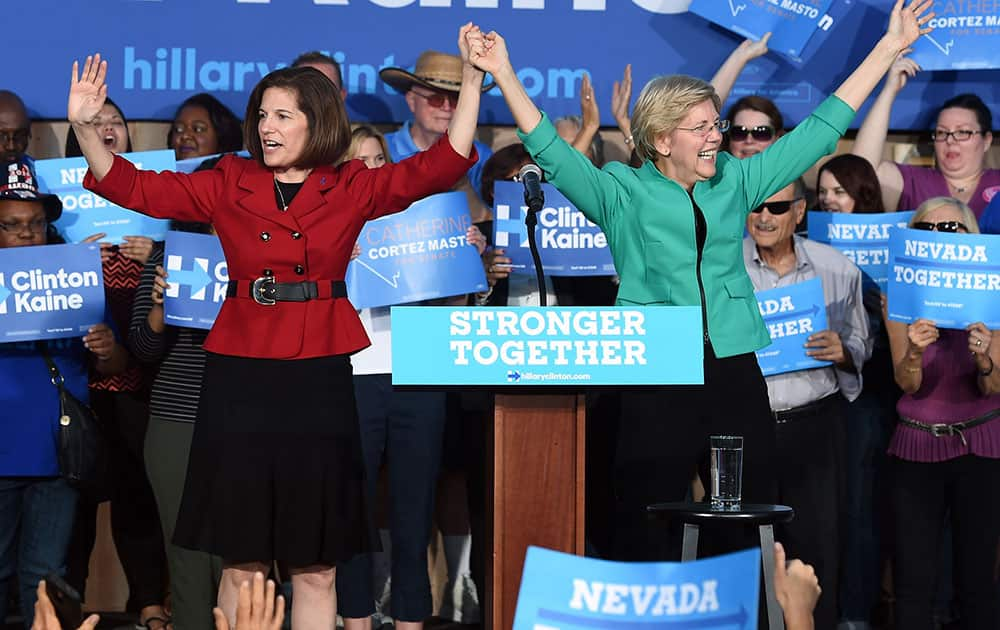 Former Nevada Attorney General and U.S. Senate candidate Catherine Cortez Masto (L) and U.S. Sen. Elizabeth Warren (D-MA) gesture to the crowd after speaking at The Springs Preserve