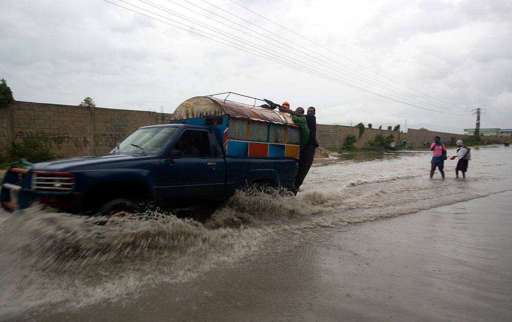 A tap-tap truck carrying commuters drives through a street flooded by rain brought by Hurricane Matthew in Port-au-Prince, Haiti