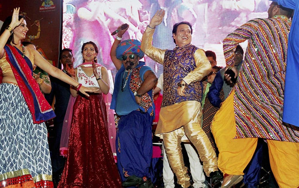 Bollywood actor Govinda dances with artists at a Garba function