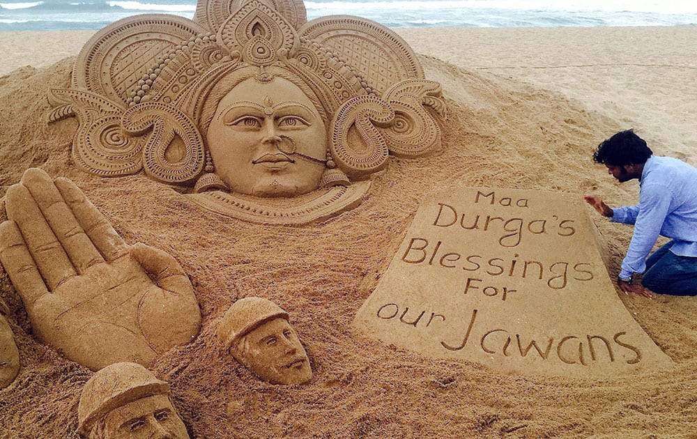 Sand artist Sudarshan Pattnaik makes a sand art of Goddess Durga with the message Maa Durgas blessings for our jawans at Puri beach