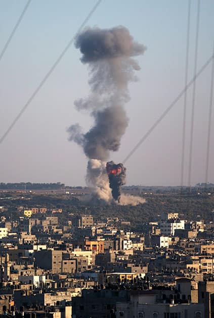 Tall plumes of smoke rise from an Israeli missile strike in Gaza