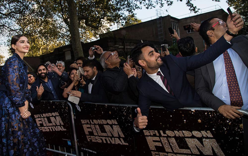 Actress Sonam Kapoor poses for selfies with fans upon arrival at the premiere of the film Mirzya at the London Film Festival