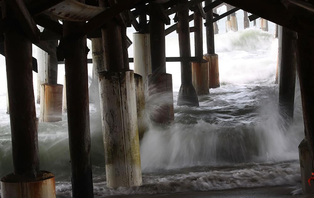Waves from approching Hurricane Matthew churn up underneath the Cocoa Beach Pier on Cocoa Beach, Florida
