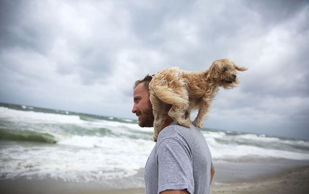 Ted Houston and his dog Kermit visit the beach as Hurricane Matthew approaches the area in Palm Beach, United States