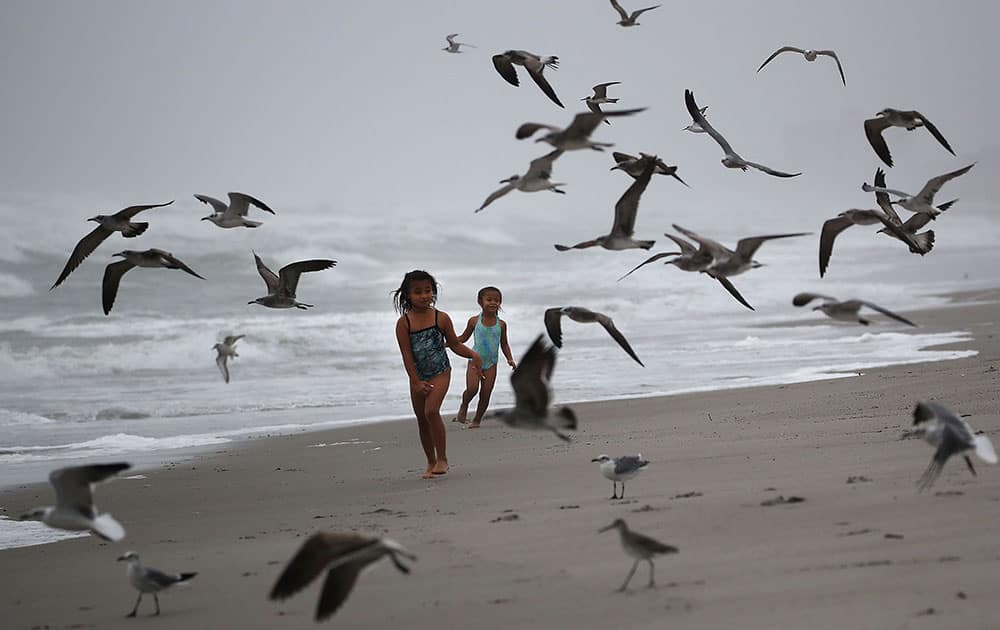 Kayla Pressinger, 7, and Lexi Pressinger, 5, enjoy their day off from school chasing birds on the beach as Hurricane Matthew approaches the area on Cocoa Beach