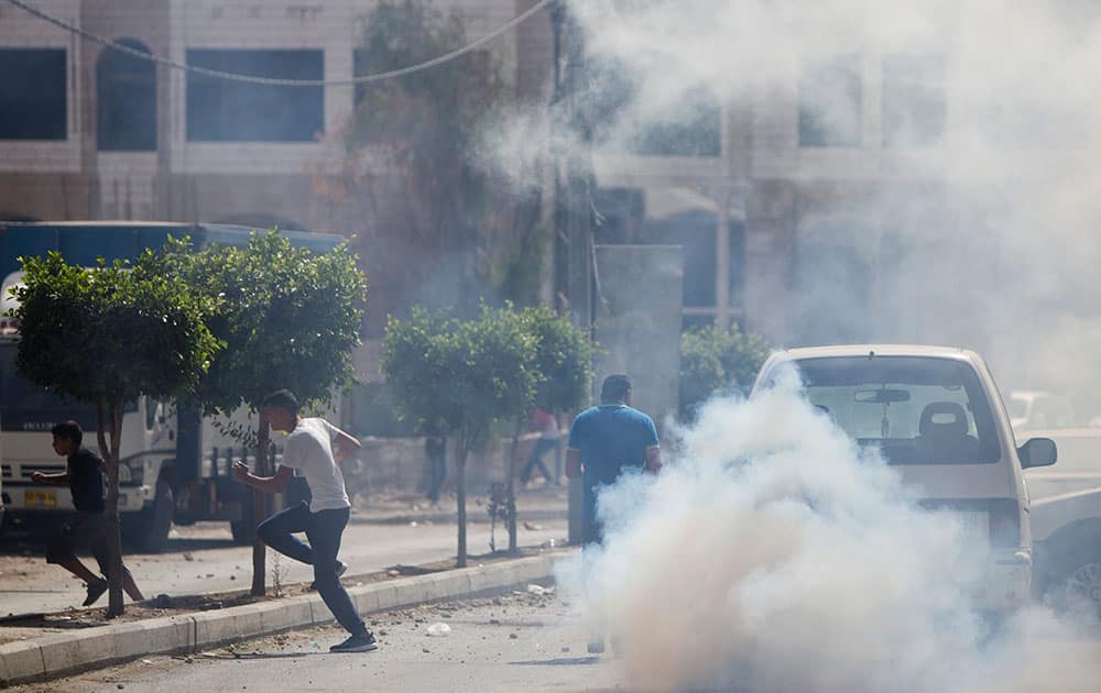 Palestinians run away from teargas as Israeli border police unit raided the family home of the Palestinian gunman who killed two and wounded several other people in Jerusalem earlier in the day, in the West Bank town of al Ram, north of Jerusalem Palestinians run away from teargas as Israeli border police unit raided the family home of the Palestinian gunman who killed two and wounded several other people in Jerusalem earlier in the day, in the West Bank town of al Ram, north of Jerusalem