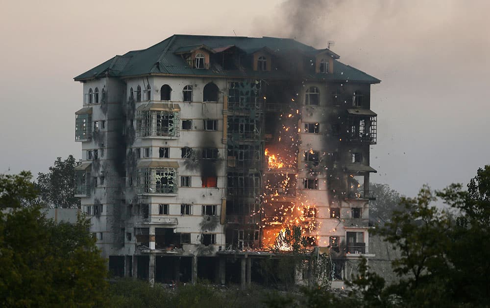 Fire and smoke rises from the government building where suspected militants have taken refuge during a gun battle in Pampore, 16 kms from Srinagar