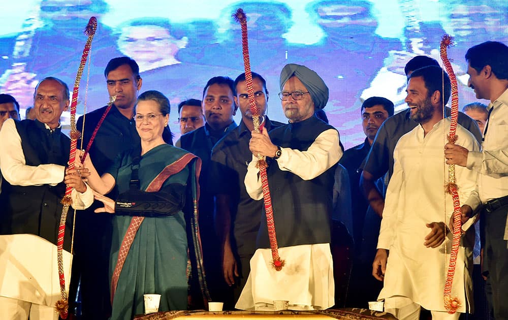 Congress President Sonia Gandhi, former PM Manmohan Singh and Congress Vice President Rahul Gandhi holding bows and arrows during Dussehra celebrations