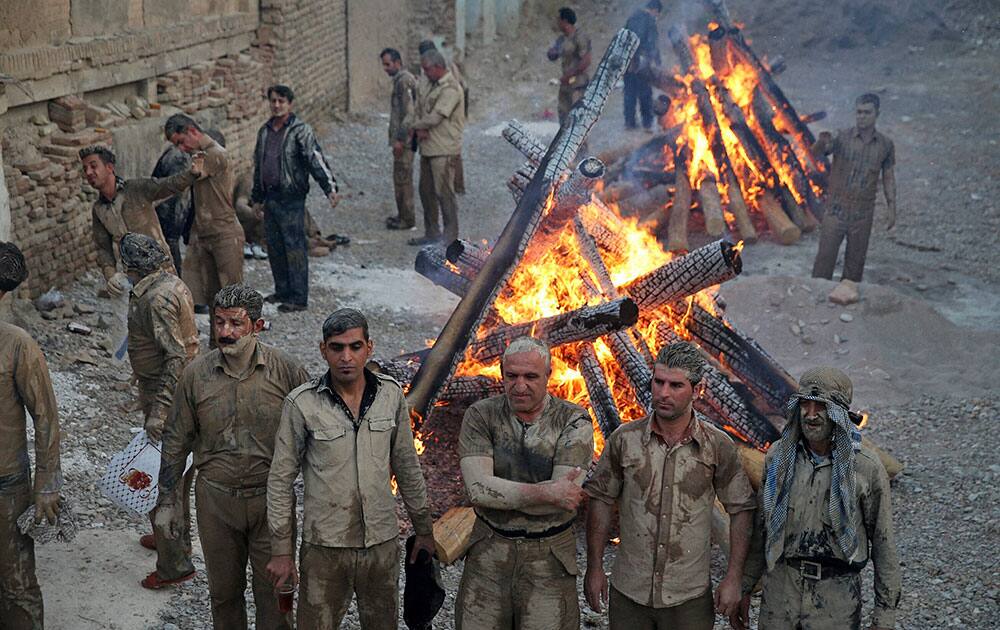 Iranian Shiite Muslims mourn after covering themselves with mud during Ashoura rituals, in Khorramabad, Iran