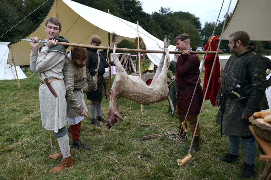 re-enactors prepare to cook a deer