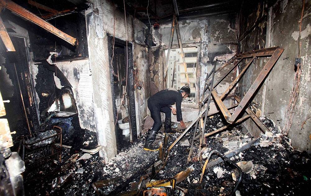 A Fireman sifts through the burnt debris of the residential apartment in Cuffe Parades Maker Chambers in Mumbai