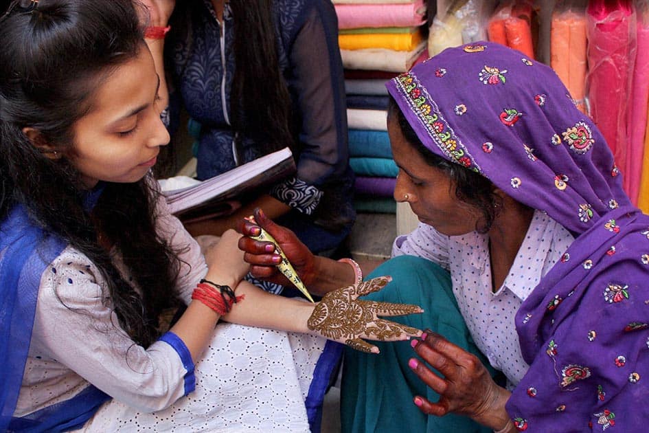 Women get mehndi (henna) designs on their palms ahead of Karva Chauth