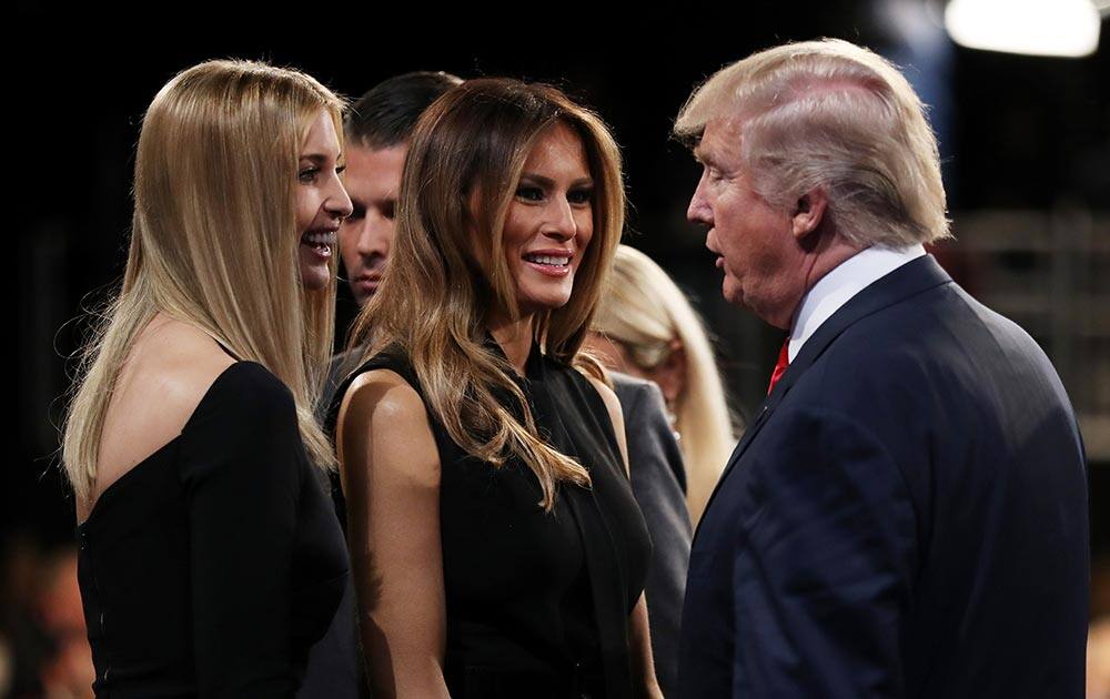 Donald Trump speaks with his wife Melania Trump