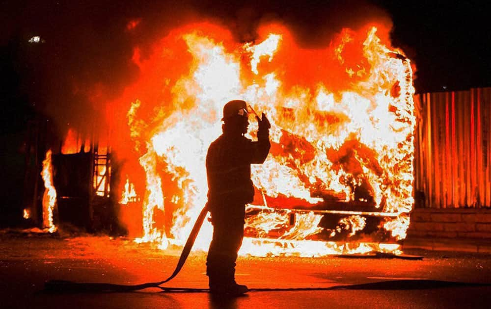 A fireman stands at a burning bus in Braamfontein