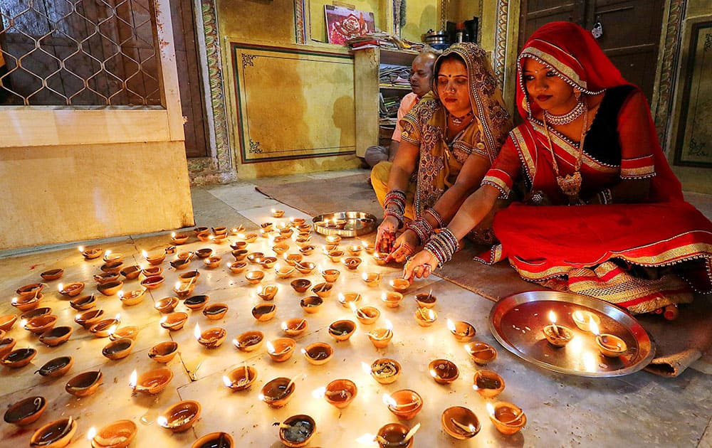 Women light earthen lamps Diyas at Ramchandran Ji temple on the occasion of Diwali Festival in Jaipur