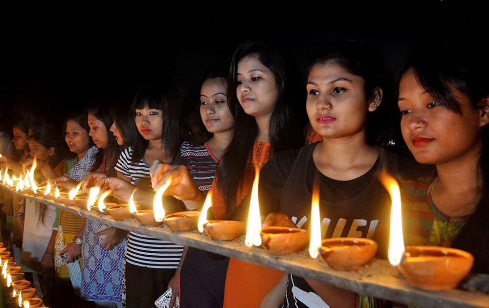 Members of the All Assam Students Union (AASU) light earthen lamps on the eight anniversary of 2008 serial bomb blast at Latasil playground in Guwahati