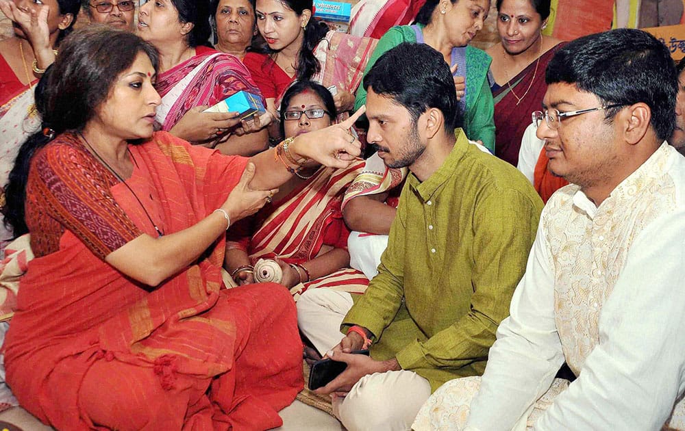 Rupa Ganguly offering sweets to a party activist during Bhai Phonta or Bhai Dooj