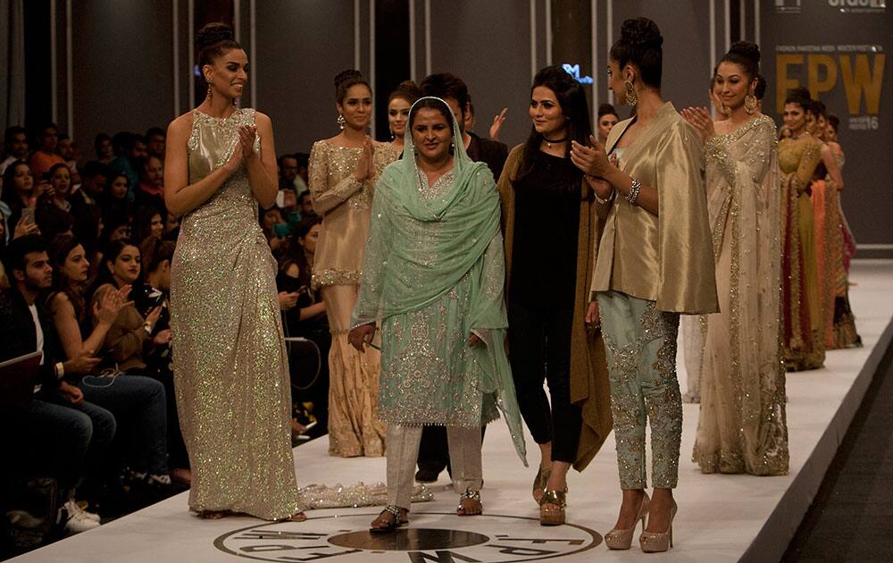 Pakistan's gang rape victim Mukhtar Mai walks with models during a fashion show in Karachi, Pakistan