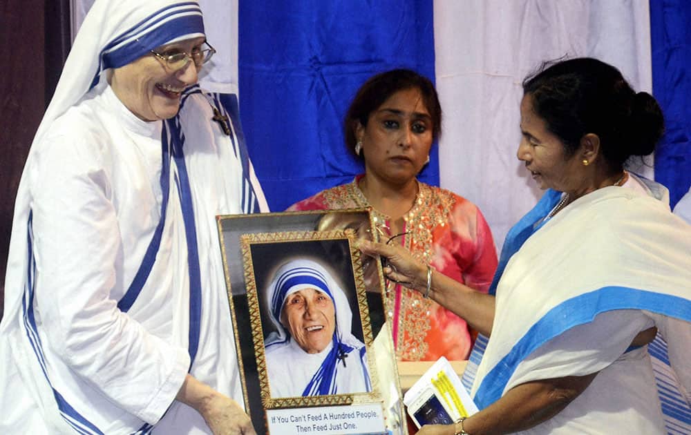 West Bengal Chief Minister Mamata Banerjee receives a portrait of Mother Teresa