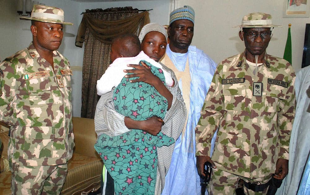 Nigerian troops stand next to a recently rescued Nigerian Chibok girl