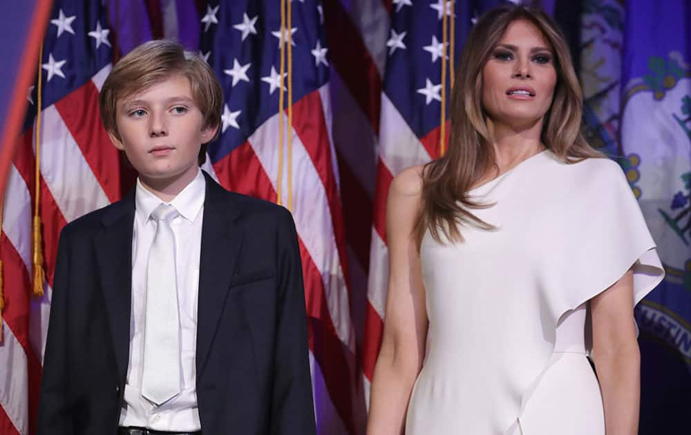 Barron Trump and his mother Melania Trump stand on stage