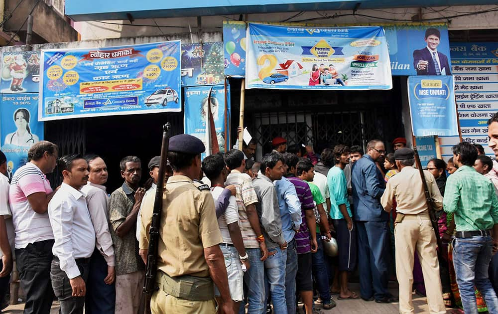 Police control the crowd of people queue up at a bank for exchanging their old Rs 1000 and Rs 500 notes in Patna