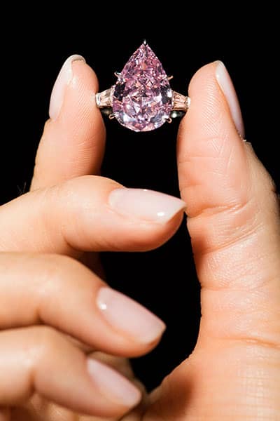 A model displays the Fancy Vivid Pink pear-shaped diamond of 9.14 carats A model displays the Fancy Vivid Pink pear-shaped diamond of 9.14 carats