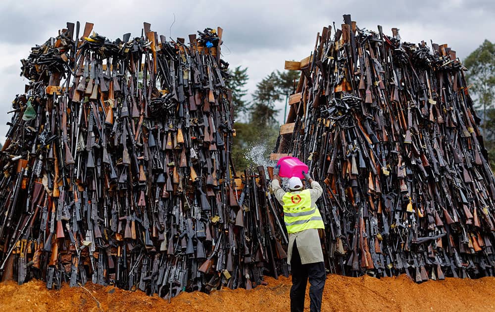 A man pours fuel on a pile of 5,250 illegal weapons before they were burned by Kenyan police