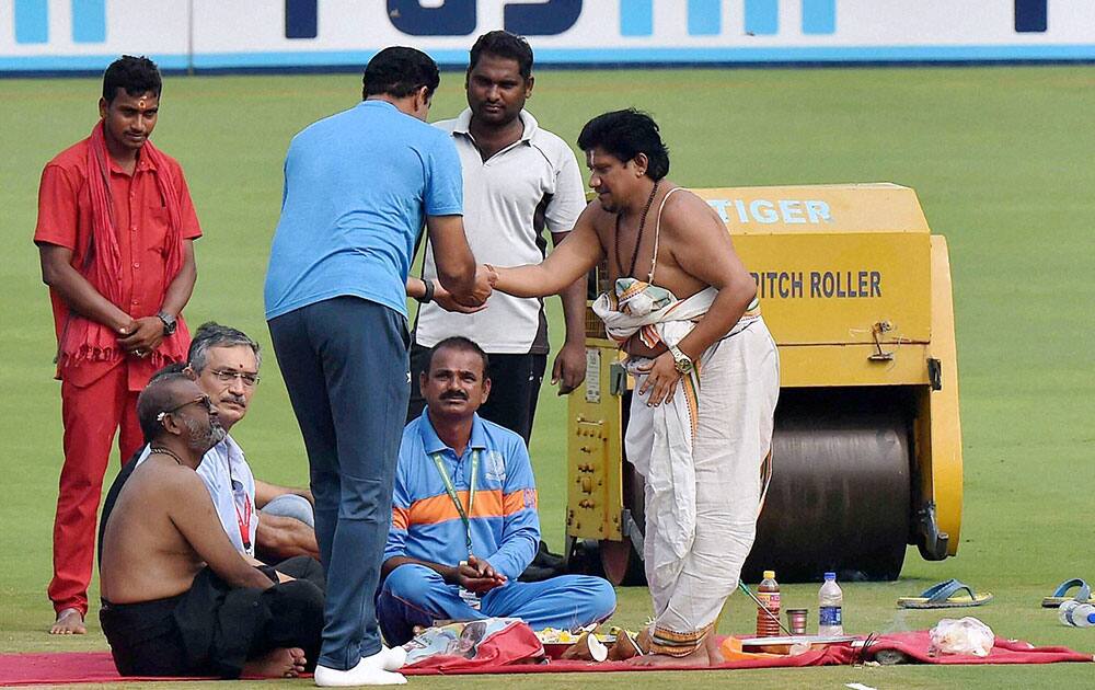 A priest gives prasad to Indian Coach Anil Kumble after pitch puja ahead of the 2nd Test cricket match against England in Visakhapatnam