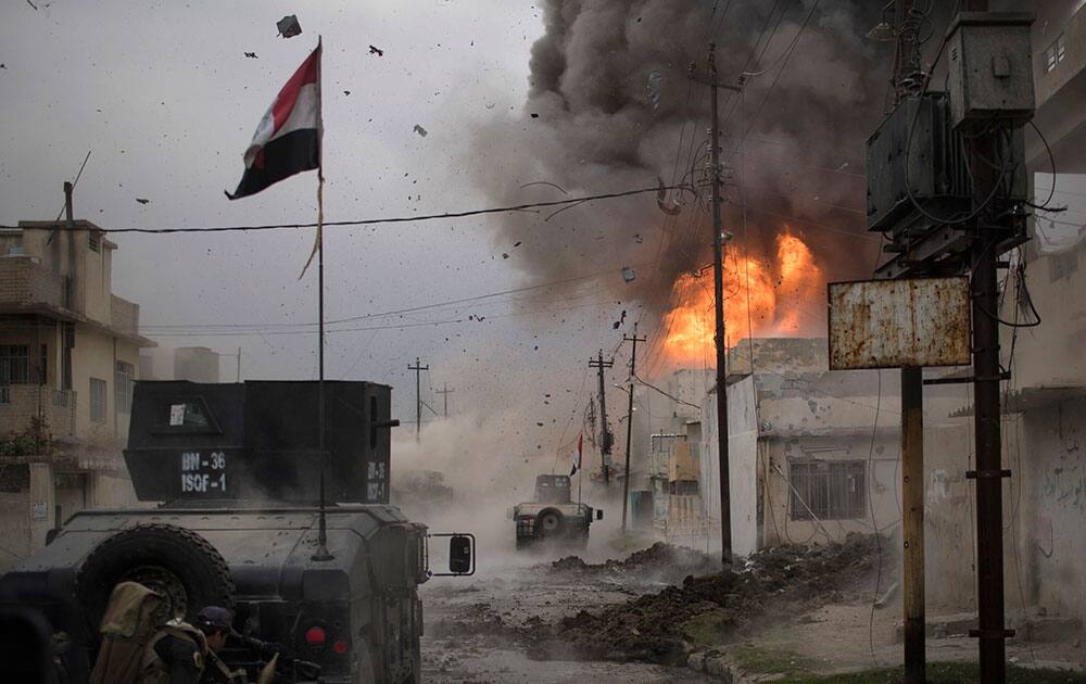 A car bomb explodes next to Iraqi special forces armored vehicles