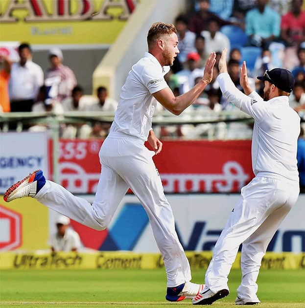 Stuart Broad celebrates with a teammate after taking a wicket during the 1st day of the 2nd Test cricket match against India in Visakhapatnam