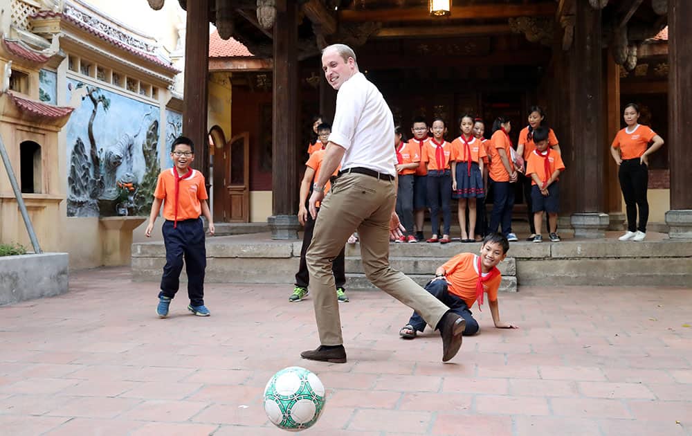 Prince William, Duke of Cambridge plays football with pupils as he visits the school on Lan Ong Street on the first day of an official visit in Hanoi, Vietnam
