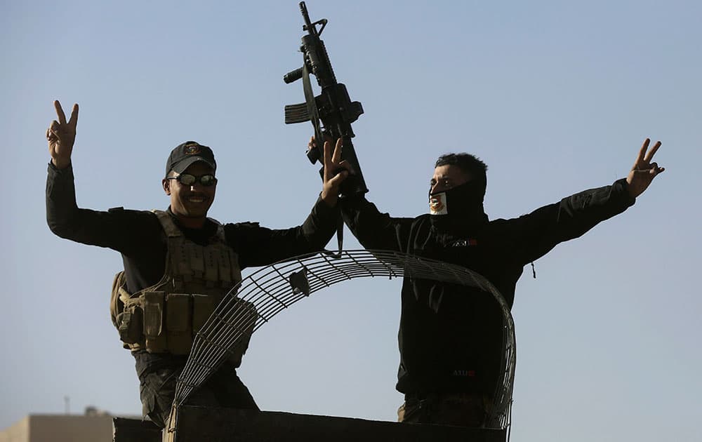 raqi special forces soldiers flash victory signs