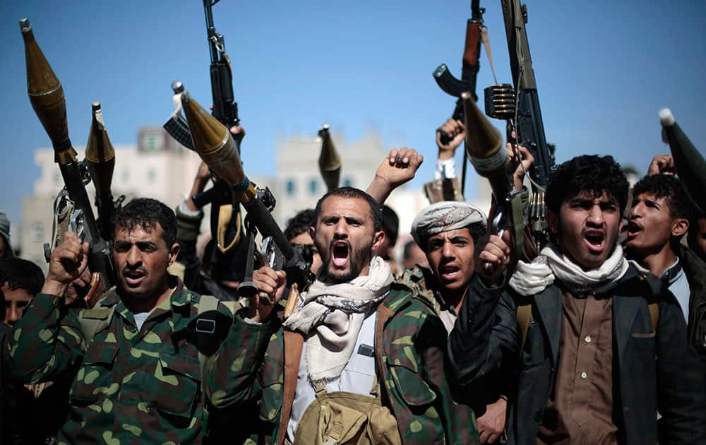 Tribesmen loyal to Houthi rebels hold their weapons 