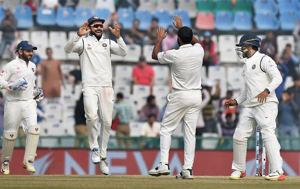 Virat Kohli celebrates with Mohammed Shami the wicket of England batsman Chris Woakes