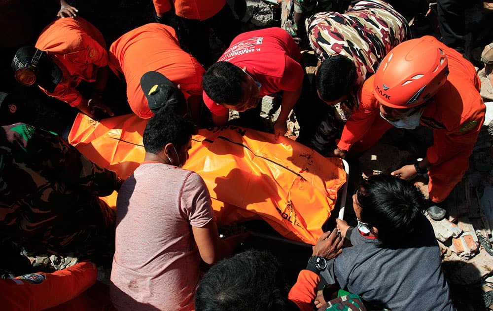 Rescue workers pull victims from destroyed buildings in Sigli, Aceh Province, Indonesia