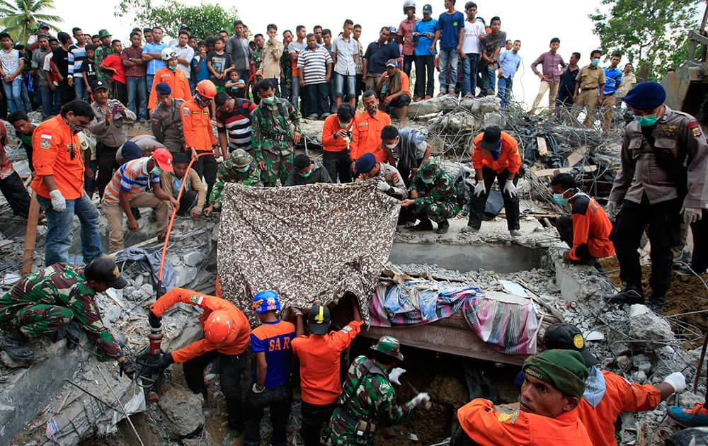 Indonesian army and the Search and Rescue Team look for survivors amongst the rubble in Lueng Putu town, Aceh Province, Indonesia